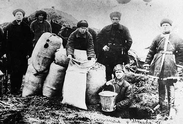 Члены рабочей бригады изымают скрытый кулаками хлеб